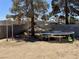 Spacious backyard featuring a trampoline, shade structure, and mature trees at 5157 New Bedford Dr, Las Vegas, NV 89122