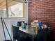 Dining area adjacent to the kitchen with brick accent wall and a bright window at 5157 New Bedford Dr, Las Vegas, NV 89122