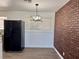 The dining room features a modern chandelier, stainless fridge, and brick accent wall at 5157 New Bedford Dr, Las Vegas, NV 89122