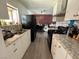 Bright kitchen showcases white cabinetry, stainless steel sink, black refrigerator, and dining area with brick accent wall at 5157 New Bedford Dr, Las Vegas, NV 89122