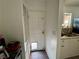 Hallway with back door and a glimpse of the kitchen area with sink and natural light at 5157 New Bedford Dr, Las Vegas, NV 89122
