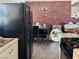 Kitchen area with white cabinets, black appliances, brick wall accent, and adjacent dining area at 5157 New Bedford Dr, Las Vegas, NV 89122