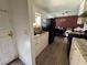 Cozy kitchen with white cabinets, a black refrigerator, and an open dining area with a brick wall accent at 5157 New Bedford Dr, Las Vegas, NV 89122