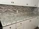 Bright kitchen features granite countertops, white cabinets, and decorative backsplash at 5157 New Bedford Dr, Las Vegas, NV 89122