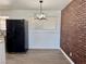 Kitchen with modern light fixture, stainless steel refrigerator and brick accent wall at 5157 New Bedford Dr, Las Vegas, NV 89122