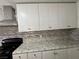 Bright kitchen features granite countertops, stainless steel appliances, and white cabinetry at 5157 New Bedford Dr, Las Vegas, NV 89122