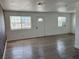 Open living room with wood-look floors and a brick accent wall at 5157 New Bedford Dr, Las Vegas, NV 89122