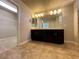 Bathroom featuring double vanity with dark wood cabinets and an open doorway to the walk-in closet at 6020 Arbor Downs Ave, Las Vegas, NV 89139