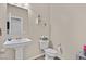 Cozy half bathroom features a pedestal sink, a toilet, neutral paint, and decorative wall shelves at 8919 Don Valley Ave, Las Vegas, NV 89148