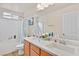 Bright bathroom with dual sinks, white tile, and combined tub and shower at 8919 Don Valley Ave, Las Vegas, NV 89148