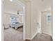 Carpeted hallway leads to a serene bedroom with a ceiling fan and a window offering natural light and views at 8919 Don Valley Ave, Las Vegas, NV 89148