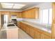 Spacious kitchen has light wood cabinets, stainless appliances, stone countertops, and tile flooring at 9904 Arbuckle Dr, Las Vegas, NV 89134