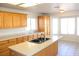 Kitchen featuring wood cabinets and a central island overlooking a dining area with a bay window at 9904 Arbuckle Dr, Las Vegas, NV 89134