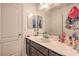 Well-lit bathroom featuring a vanity with a sink, a mirror, and a toilet with a closed door at 10509 Hartford Hills Ave, Las Vegas, NV 89166