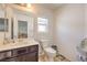 Neat bathroom featuring a dark vanity with a sink, a toilet, and neutral decor for a clean and simple design at 10509 Hartford Hills Ave, Las Vegas, NV 89166
