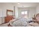 Bright bedroom featuring a wooden dresser, carpet flooring, and natural light from the sliding glass door at 10509 Hartford Hills Ave, Las Vegas, NV 89166