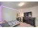 This bedroom features neutral walls, a TV atop a dresser, and charming LED strip lights at 10509 Hartford Hills Ave, Las Vegas, NV 89166