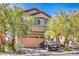 Inviting two-story home with neutral stucco and a two-car garage, enhanced by mature trees and drought-resistant landscaping at 10509 Hartford Hills Ave, Las Vegas, NV 89166
