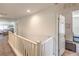 Upstairs hallway with white railing leading to bedrooms, offering a clean and bright transition space at 10509 Hartford Hills Ave, Las Vegas, NV 89166