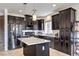 The kitchen features dark cabinetry, a center island with light countertops and stainless steel appliances at 10509 Hartford Hills Ave, Las Vegas, NV 89166