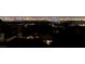 Dim city skyline at night with some illuminated buildings and rooftops in foreground at 10729 Marathon Bell Ln, Las Vegas, NV 89129