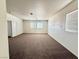 Spacious bedroom featuring brown carpet, white walls, and natural light from multiple windows at 108 Spur Ranch Ave, North Las Vegas, NV 89032