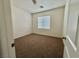 Neutral bedroom with brown carpet, white walls, and bright natural light streaming through the window at 108 Spur Ranch Ave, North Las Vegas, NV 89032