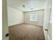 Neutral bedroom with brown carpet, white walls, and bright natural light streaming through the window at 108 Spur Ranch Ave, North Las Vegas, NV 89032