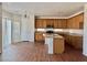 Spacious kitchen featuring light wood cabinets, island with sink, and stainless steel appliances at 108 Spur Ranch Ave, North Las Vegas, NV 89032