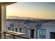 Inviting balcony view overlooking modern rooftops and the Las Vegas skyline against a mountain backdrop at sunset at 1103 Tektite Ave, Henderson, NV 89011