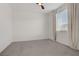 A bright, carpeted bedroom with a ceiling fan and a window with blinds and curtains at 1103 Tektite Ave, Henderson, NV 89011