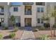Charming two-story townhouse showcases a walkway, stone facade, small trees, and manicured landscape at 1103 Tektite Ave, Henderson, NV 89011