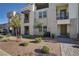 Attractive townhouse featuring a private balcony, stone facade, small trees, and xeriscaped landscaping at 1103 Tektite Ave, Henderson, NV 89011
