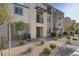 Attractive townhouse showcases walkway, stone facade, small trees, and xeriscaped landscaping at 1103 Tektite Ave, Henderson, NV 89011
