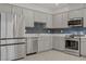 Well-equipped kitchen with stainless steel appliances, stylish blue backsplash, ample cabinetry, and quartz countertops at 1103 Tektite Ave, Henderson, NV 89011
