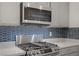 Modern stainless steel gas range stove with blue backsplash and countertop at 1103 Tektite Ave, Henderson, NV 89011
