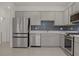 Modern kitchen featuring stainless steel appliances, gray cabinetry, and a blue backsplash at 1103 Tektite Ave, Henderson, NV 89011