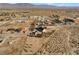 Wide aerial view of tan home with outbuildings, large desert property, and mountain views in the distance at 170 Story Ave, Pahrump, NV 89060