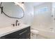 Well-lit bathroom featuring a dark vanity with white countertop, a toilet, and a tiled shower/tub combo at 170 Story Ave, Pahrump, NV 89060