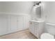Modern bathroom featuring white cabinets, sink, toilet, and built-in storage with wood floors at 170 Story Ave, Pahrump, NV 89060