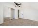 Carpeted bedroom featuring mirrored closet doors, a ceiling fan, and neutral walls at 170 Story Ave, Pahrump, NV 89060