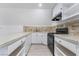 Bright kitchen showcasing white cabinets, countertops, black appliances, and wood-look flooring at 170 Story Ave, Pahrump, NV 89060
