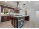 Modern kitchen with dark wood cabinets, granite countertops, stainless steel appliances, and a large center island at 170 Story Ave, Pahrump, NV 89060