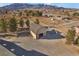Aerial view of barn with large roll-up doors and lean-to in the desert with mountain backdrop at 170 Story Ave, Pahrump, NV 89060