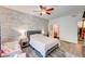 Bedroom featuring a textured wall, ceiling fan, and a bed with a white comforter, plus a separate toddler bed at 1713 Queen Victoria St # 104, Las Vegas, NV 89144