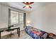 Cozy bedroom with a ceiling fan, a window, a desk, and a bed with a patterned comforter at 1713 Queen Victoria St # 104, Las Vegas, NV 89144