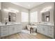Spa-like bathroom with dual vanities, a freestanding tub, glass block windows, and modern lighting fixtures at 2264 Savannah River St, Henderson, NV 89044