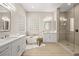 Modern bathroom featuring double vanity, free-standing tub with wooden stool, and glass enclosed shower at 2264 Savannah River St, Henderson, NV 89044