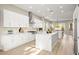Modern kitchen features white cabinets, stainless appliances, quartz countertops, and large island with open floor plan at 2264 Savannah River St, Henderson, NV 89044