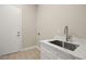 Laundry room with a stainless steel sink, marble countertop and white shaker cabinets at 2264 Savannah River St, Henderson, NV 89044